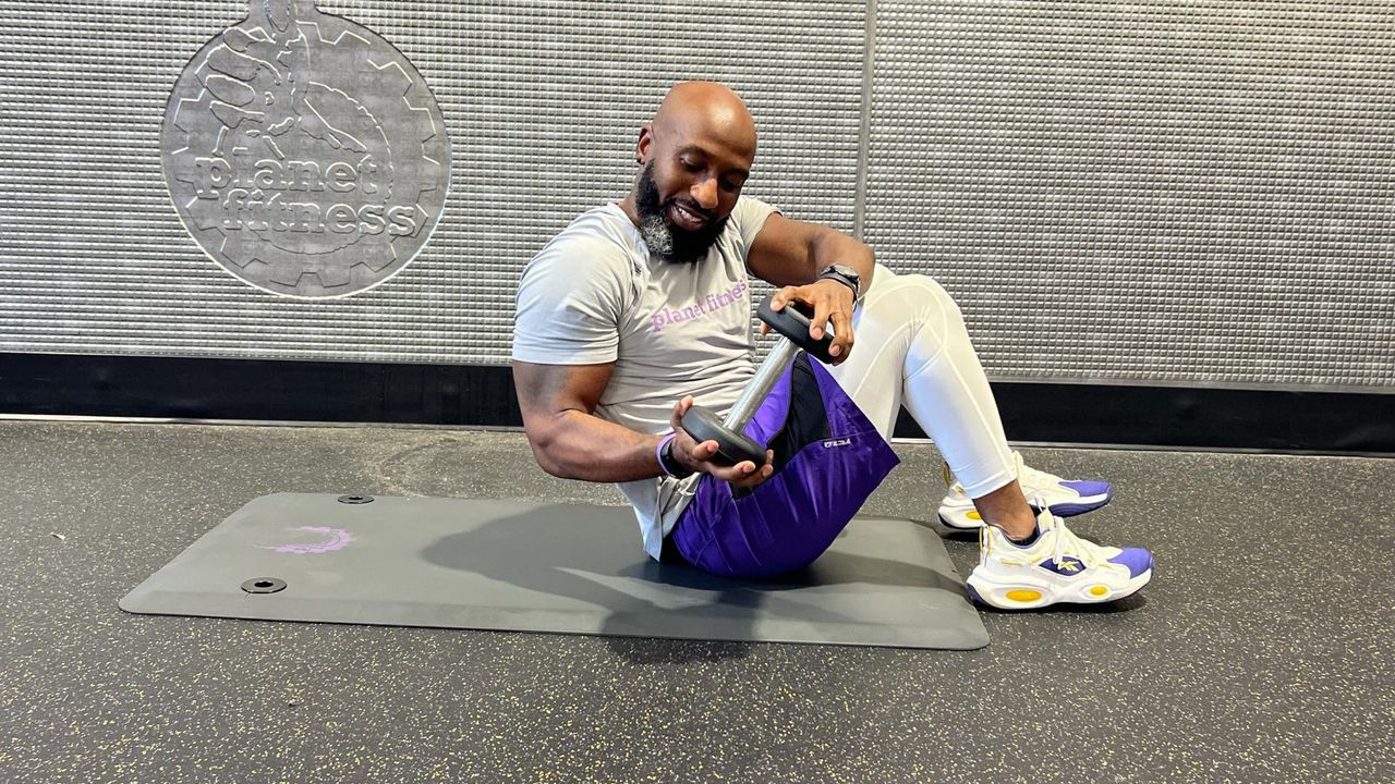 Teddy Savage doing a dumbbell sit-up Russian twist