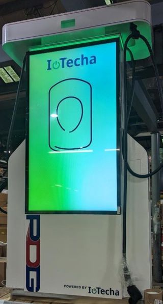 An EV charging kiosk lit up with digital signage from Samsung, IoTecha, and PDG.