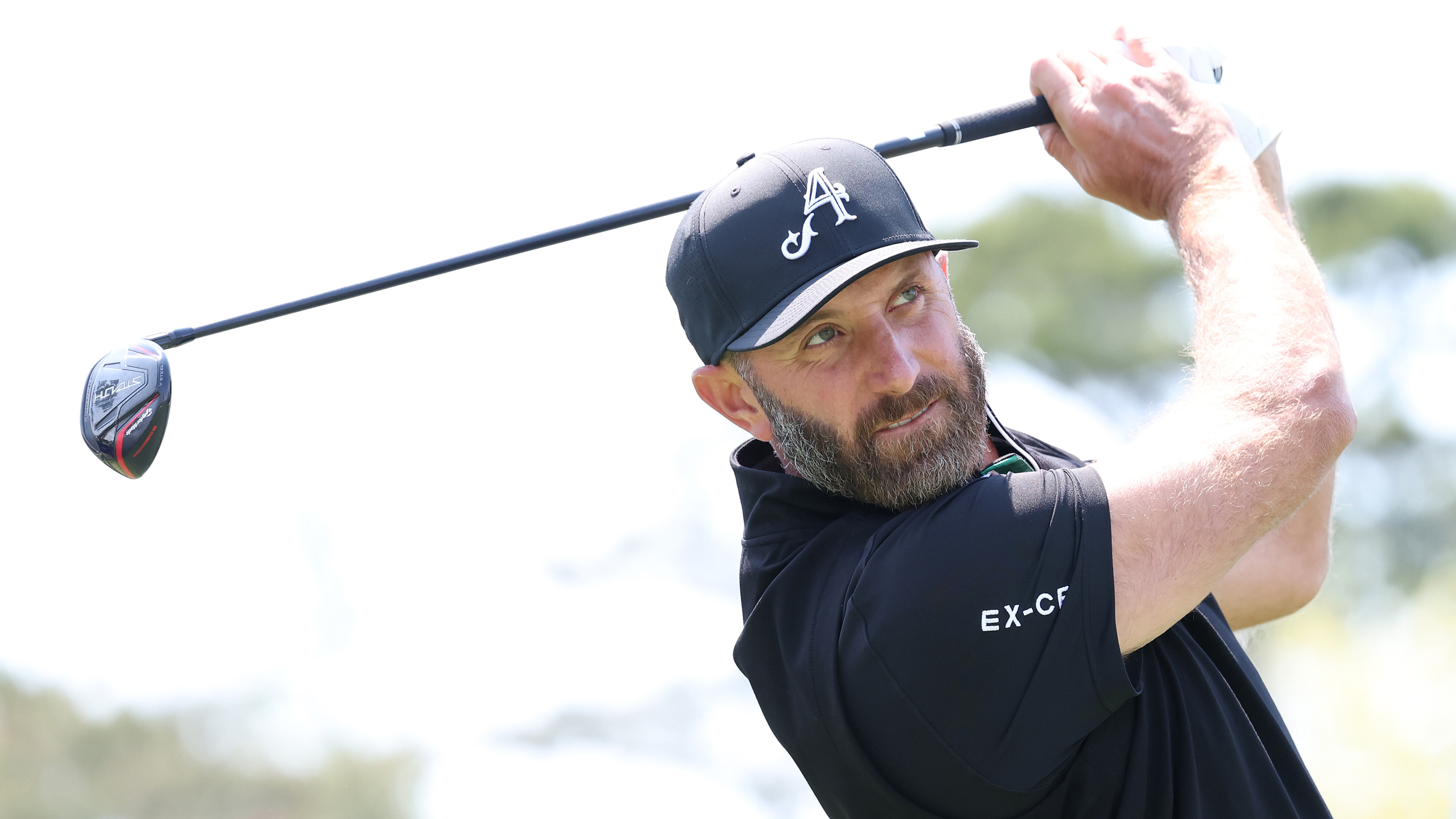 Dustin Johnson holds his finish on a fairway wood shot
