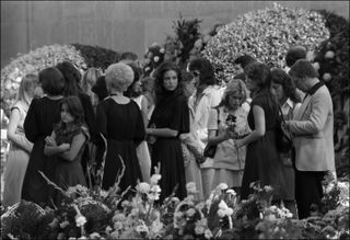 A black and white photo of mourners at Elvis' funeral