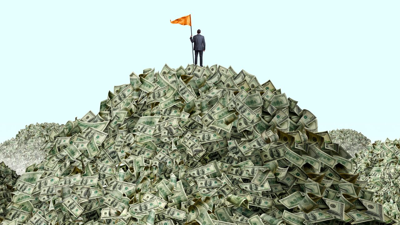 man standing on a pile of money