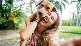 woman taking selfie cuddling dog