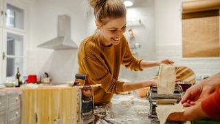 A lady makes pasta from scratch at home