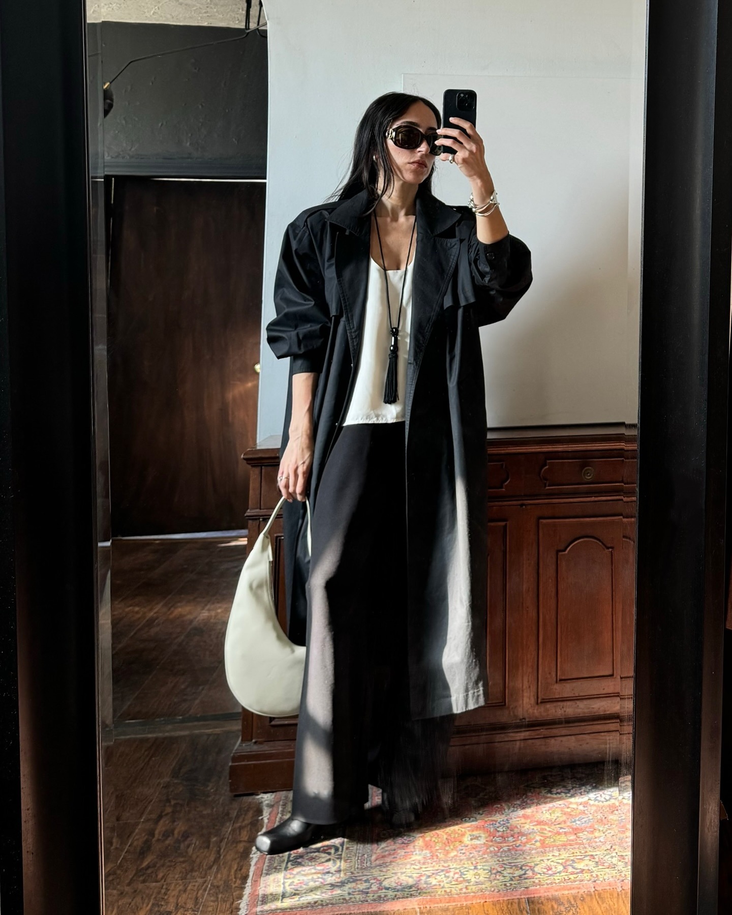 Alexis wore a black coat, white top, black pants, black tassel necklace and black sunglasses.