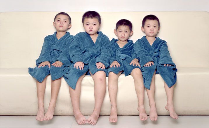 Four barefoot children with matching blue dressing gowns