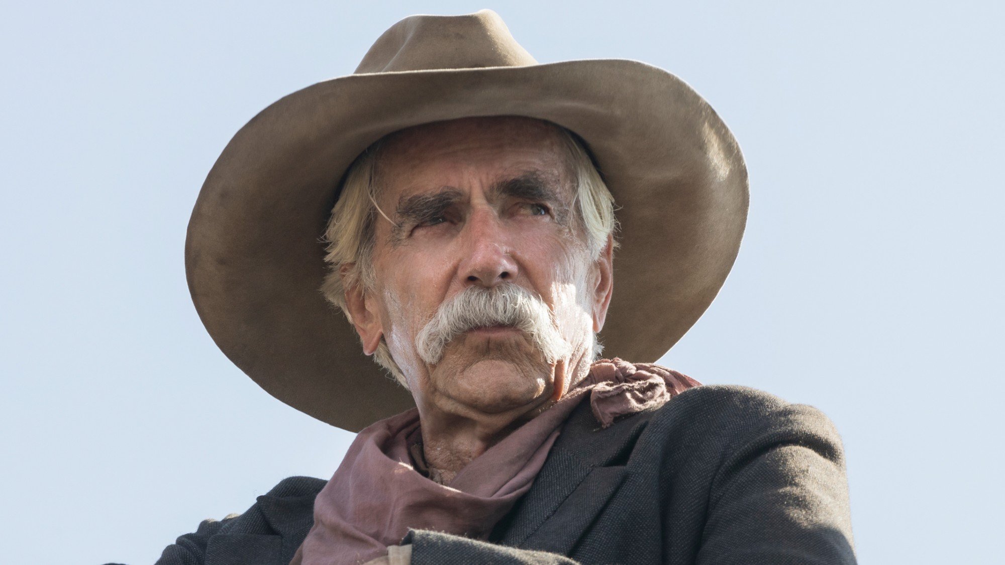 Sam Elliott wearing a cowboy hat and looking to his right in 1883.