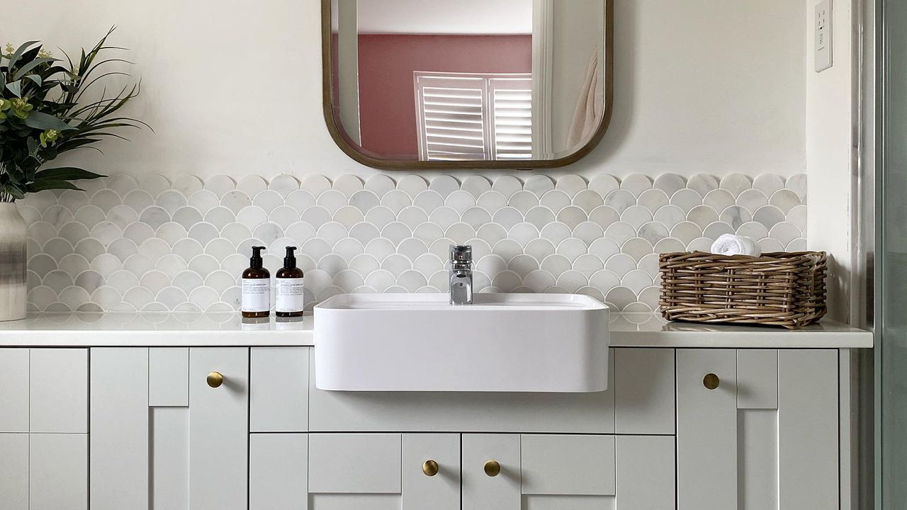 neutral en suite bathroom with a sink and mirror over a vanity