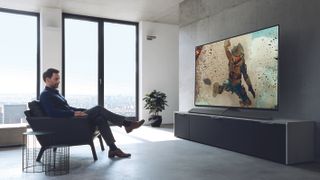 Una persona viendo una película de acción sentada en un sillón frente al televisor