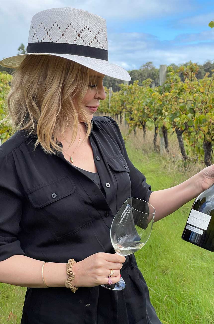 Kylie tasting wine in a vineyard