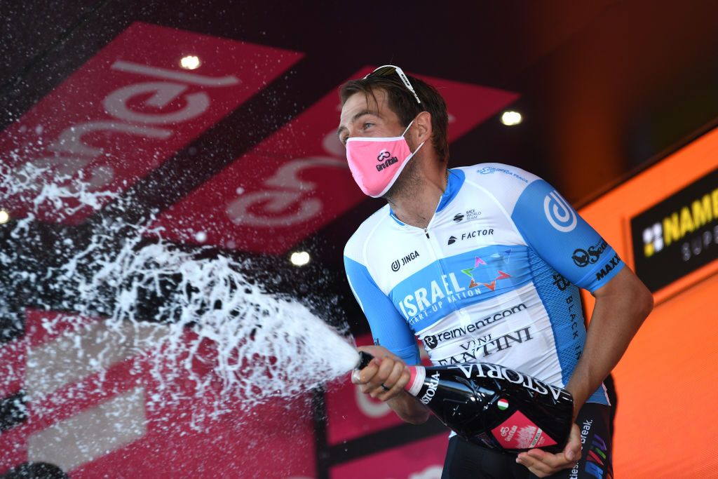 VIESTE ITALY OCTOBER 10 Podium Alex Dowsett of The United Kingdom and Team Israel StartUp Nation Celebration Champagne Mask Covid Safety Measures during the 103rd Giro dItalia 2020 Stage Eight a 200km stage from Giovinazzo to ViesteGargano girodiitalia Giro on October 10 2020 in Vieste Italy Photo by Tim de WaeleGetty Images