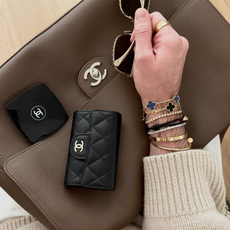 Who What Wear editor Bobby Schuessler poses with his Chanel classic flap wallet, one of the best designer luxury wallets on the market.