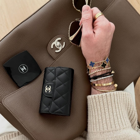 Who What Wear editor Bobby Schuessler poses with his Chanel classic flap wallet, one of the best designer luxury wallets on the market.