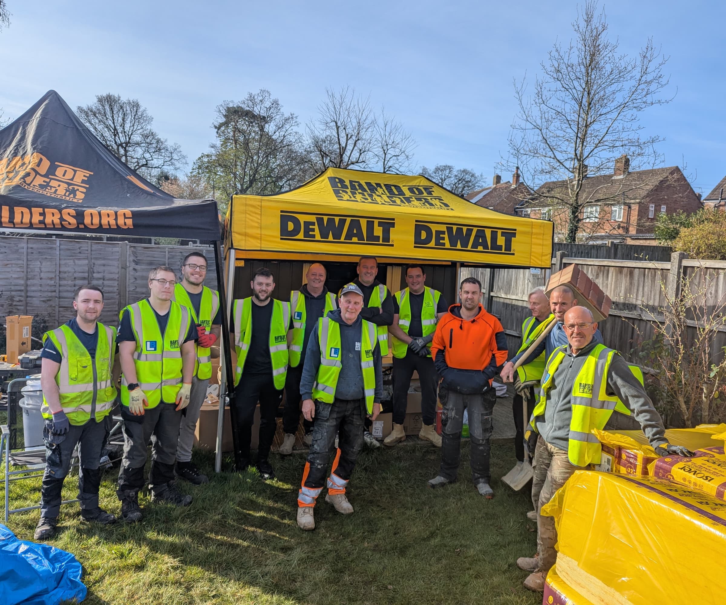 A group of builders under a tent sponsored by DeWalt