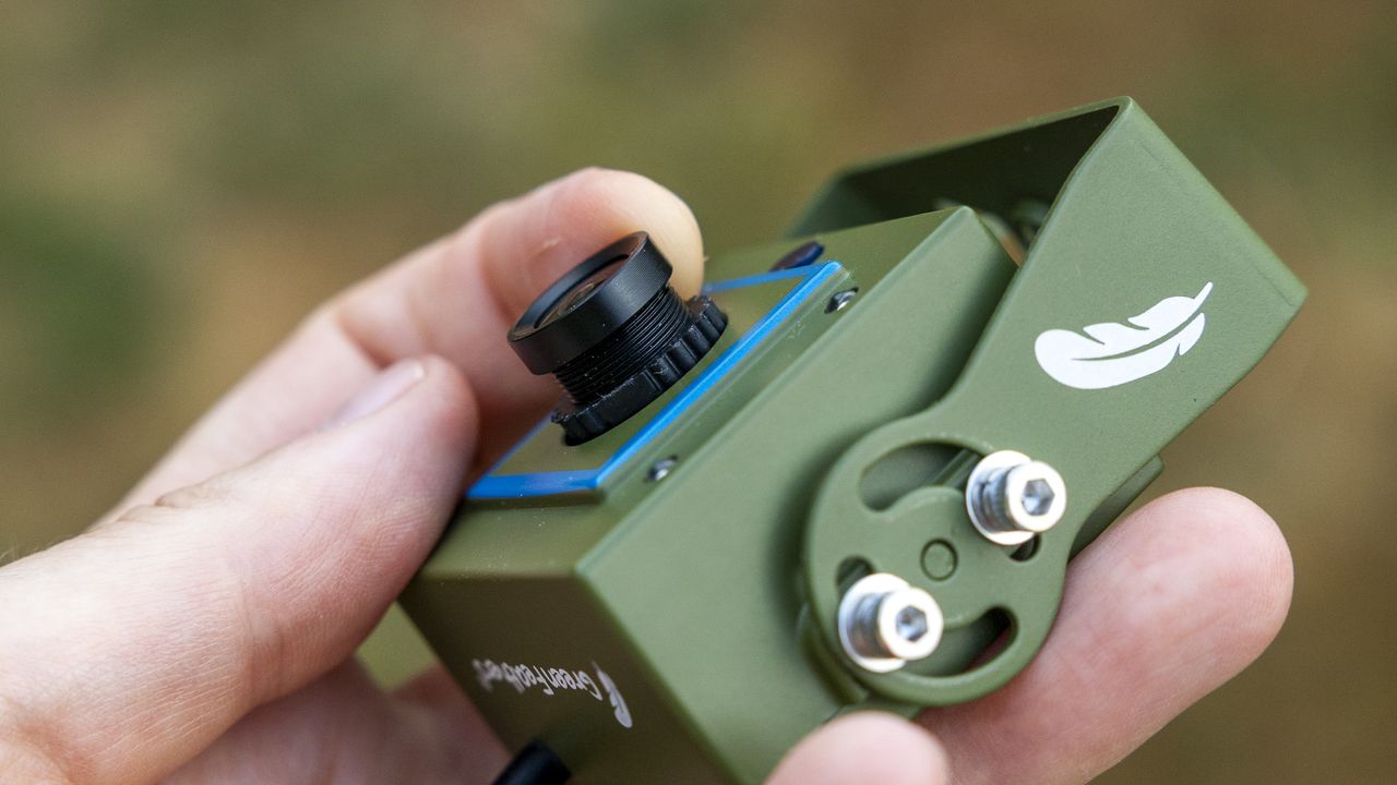 Close up of the Green Feathers TV connectable wildlife camera held in a female hand