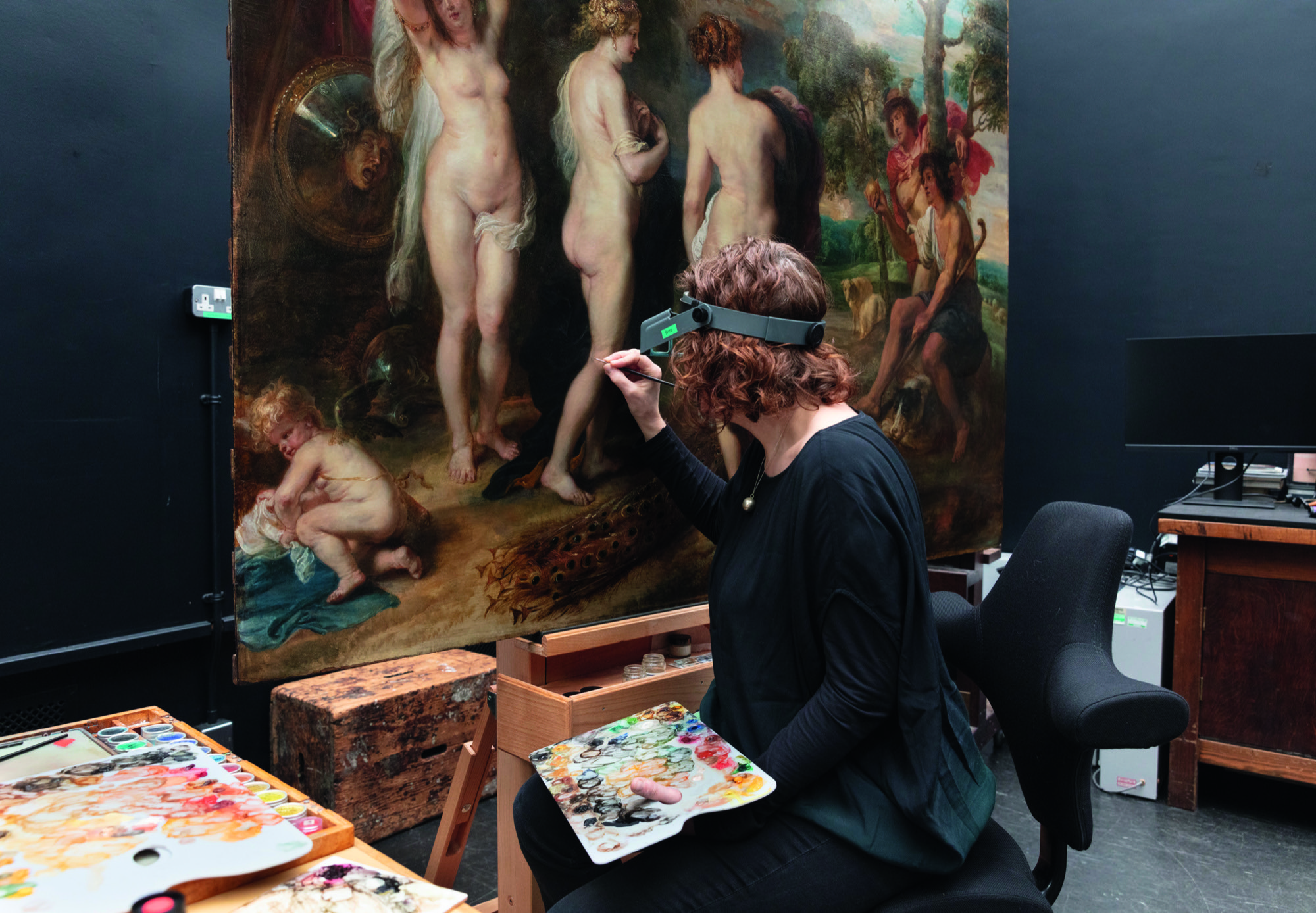 A woman wearing a special headset touches up The Judgement of Paris by Rubens at the National Gallery.