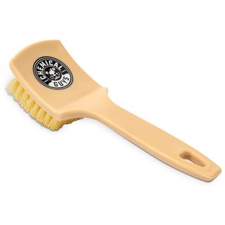 A beige carpet cleaning scrubbing brush with beige bristles and black and white circular logo