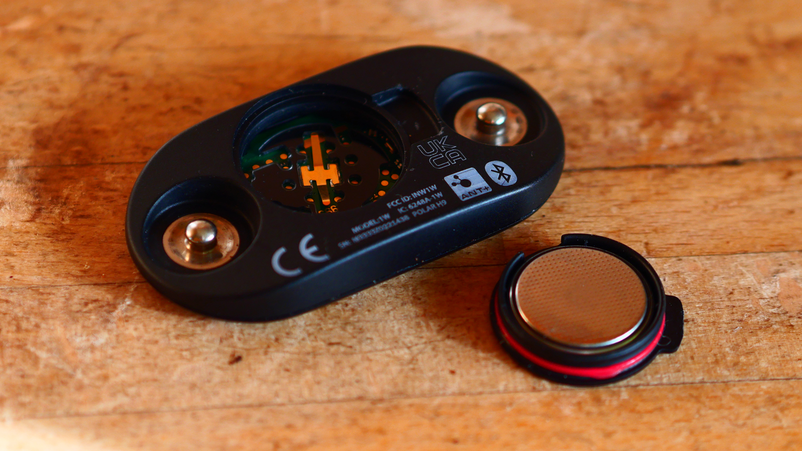 Polar H9 heart rate monitor on a wooden countr top showing battery and covre