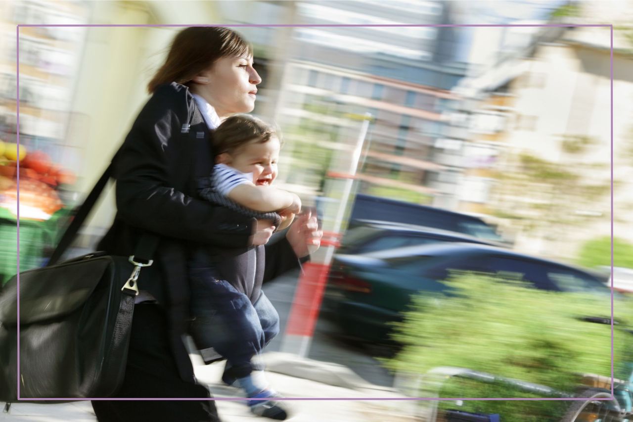 working mum with baby in slng blurred