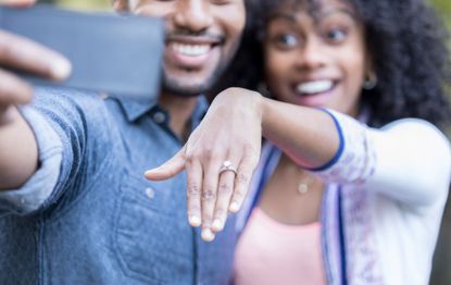 woman uses cousin's hand in engagement photo