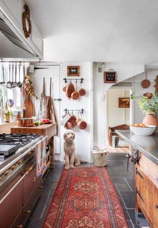 slate floor in rustic vintage kitchen with red rug