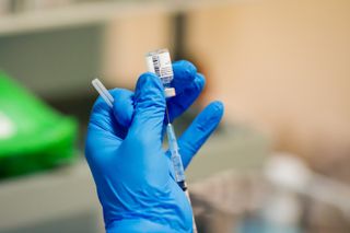 A person holding a Pfizer-BioNTech vaccine.