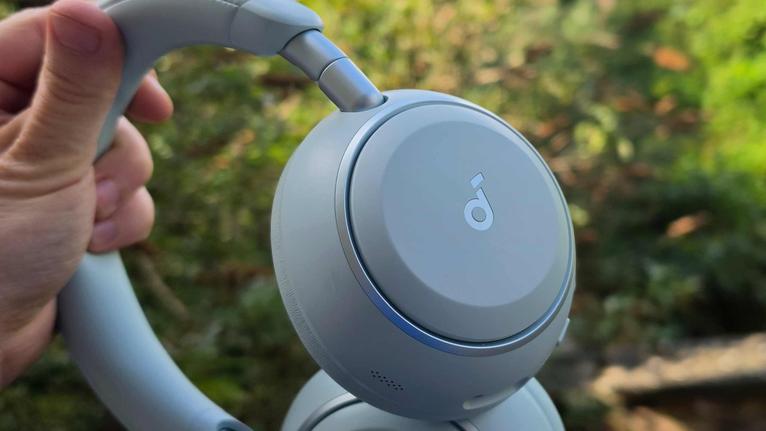 The Soundcore Space 2 in front of a green bush.