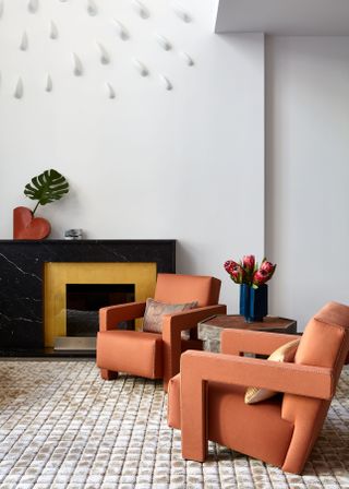 Living room with orange chairs and small hexagonal coffee table
