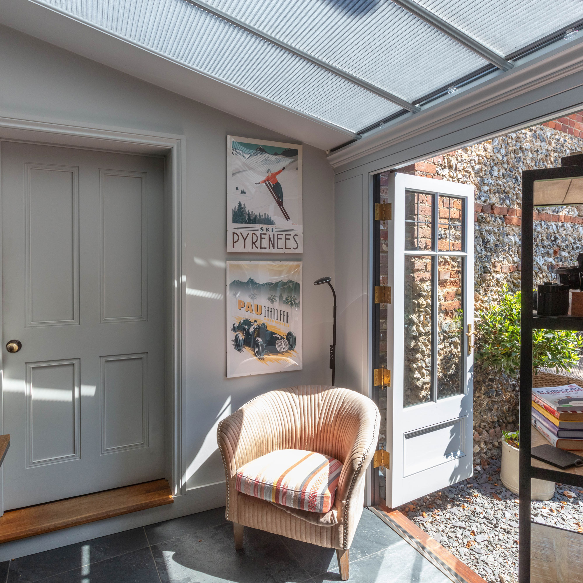 small conservatory with slate flooring and grey French doors to garden