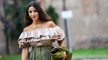 Best bright lipsticks - Bettina Looney wears a gold chain with a large heart pendant necklace, a gold necklace, a baige ruffled shoulder-off / puffy sleeves cropped t-shirt, khaki high waist oversized midi pants, a gold watch, a gold bracelet, a dark green / khaki velvet handbag, - getty images 1342003854