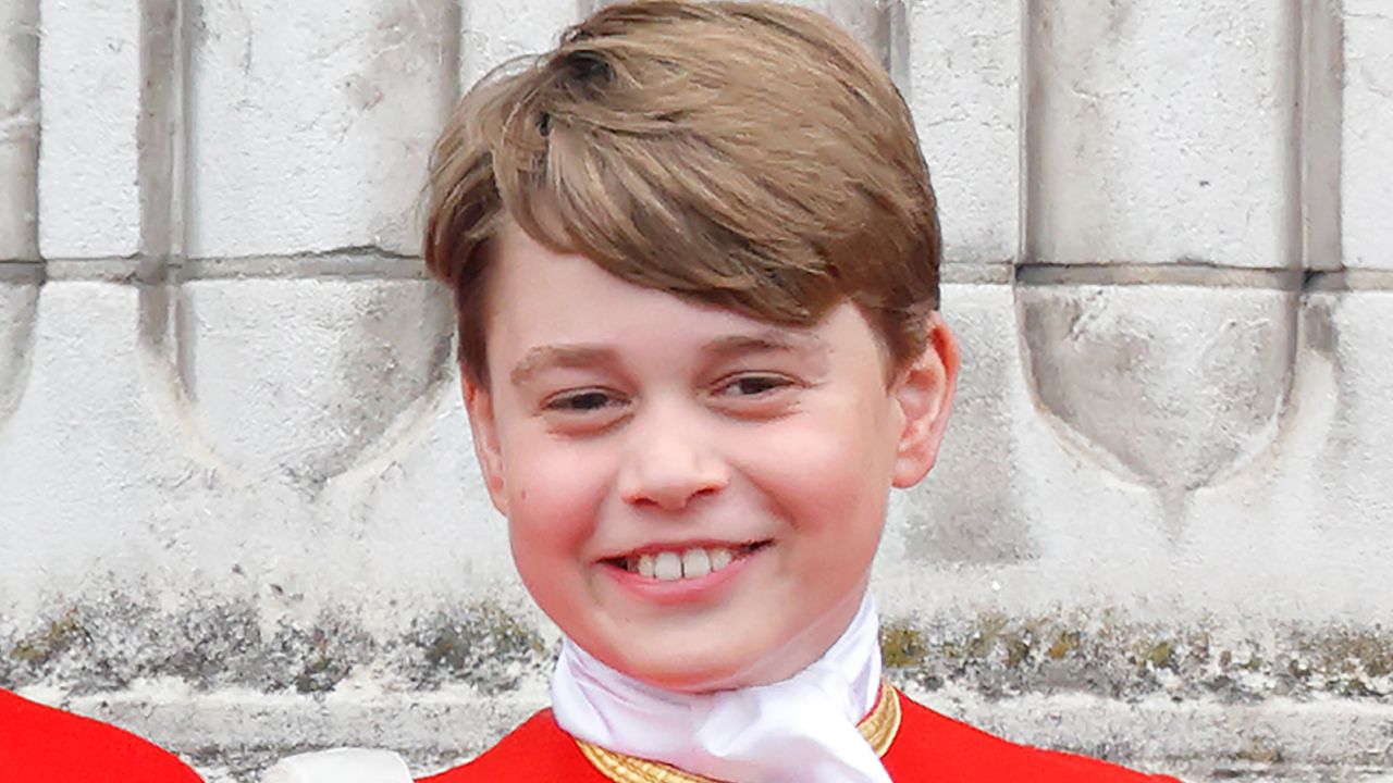 Prince George wears red uniform with gold adornments