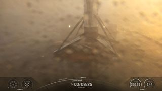 a water spattered lens shows a hazy platform with a 4-legged fuselage standing upright.