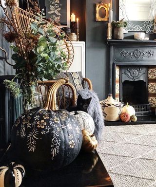A pumpkin decorating idea with black and light orange paint in living room with fireplace and rectangular mirror