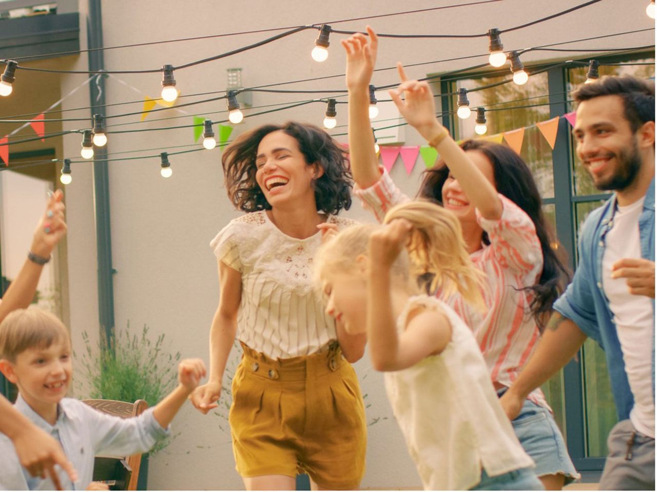 People Dancing In A Yard Under Hanging Lights