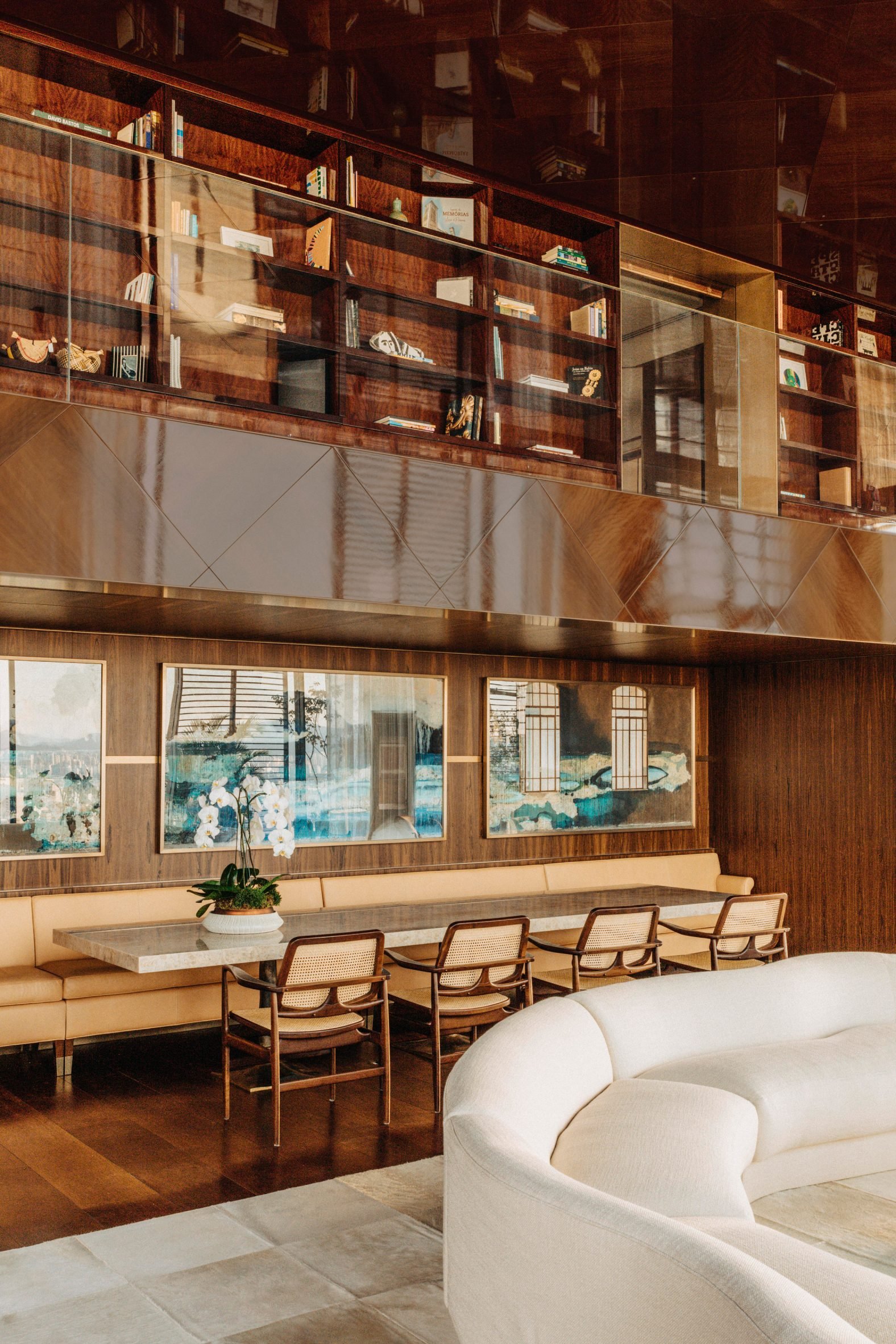 A spectacular, sun-filled penthouse blends Brazilian heritage with sleek surfaces, sculptural furniture, and researched artwork, also incorporating greenery into an earthy scheme.