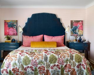 bedroom with pale pink walls, dark navy headboard and nightstands, floral bedding