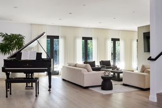 A living room with long curtains along the wall