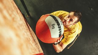 Man seen from above about to throw a large 6kg medicine ball up