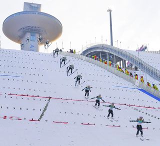 A ski jumper lands on a slope at the Pyeongchang, South Korea Winter Olympics after completing a jump.