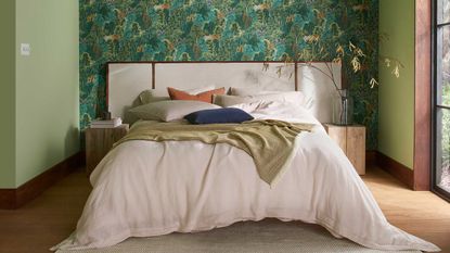 a bedroom with wallpaper and green painted wallls