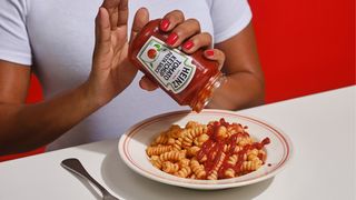 Heinz ketchup pasta sauce being tipped onto a plate of pasta