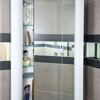 bathroom with grey tiles wall and cabinets