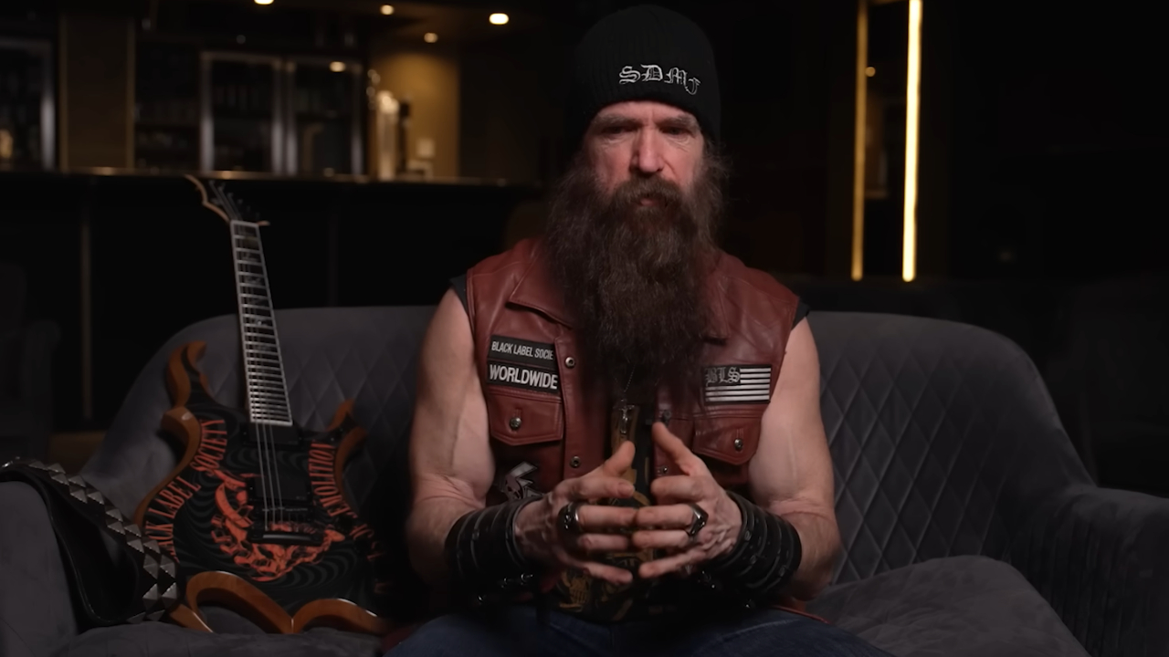 Zakk Wylde on a couch next to one of his guitars