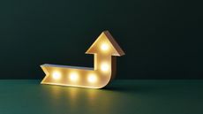 A lighted yellow arrow points up against a dark green background.