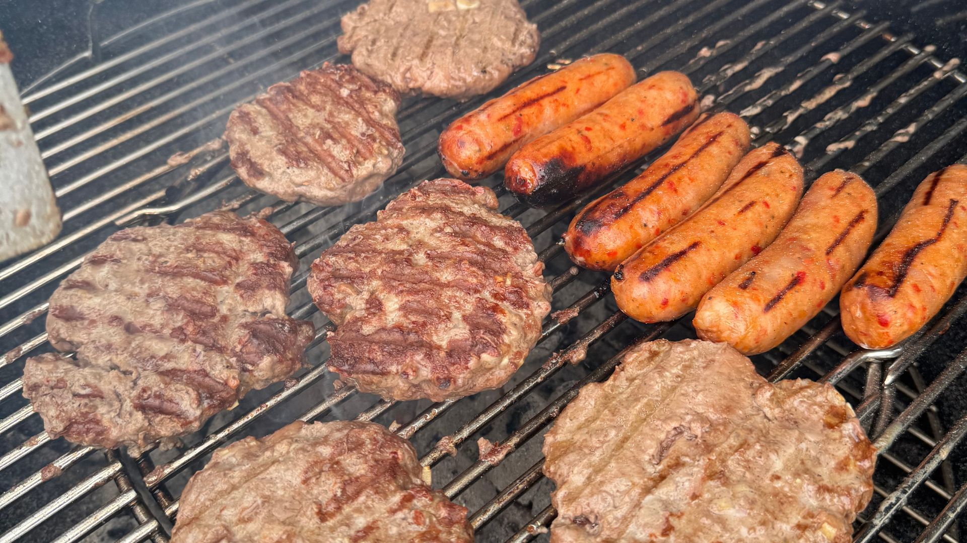 Burgers and sausages cooking on the Weber Master-Touch GBS C-5750 Charcoal Barbecue