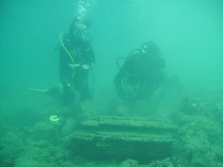 Divers examine a doughnut-shaped structure off the island of Zakynthos, Greece.