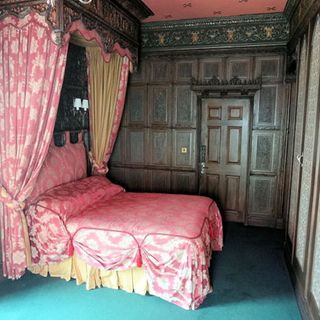 bedroom with pink bed and wooden door