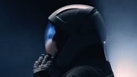 a shadowy figure in a spacesuit touches a glove to the helmet's visor.