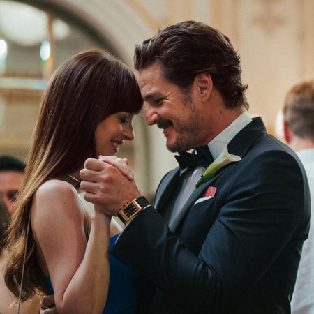 dakota johnson and pedro pascal dancing together at a wedding in materialists