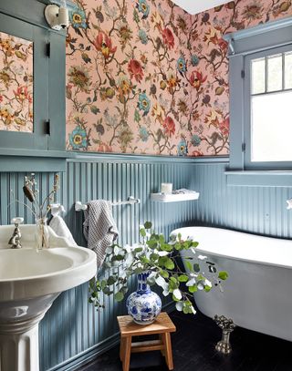 bathroom with freestanding bath, pink floral wallpaper and blue tongue and groove panelling
