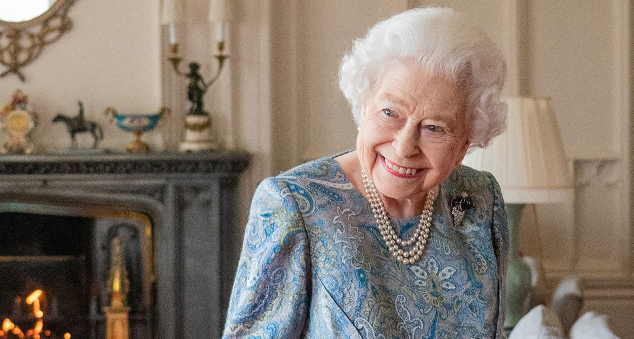 Queen Elizabeth wearing a blue paisley dress and pearls